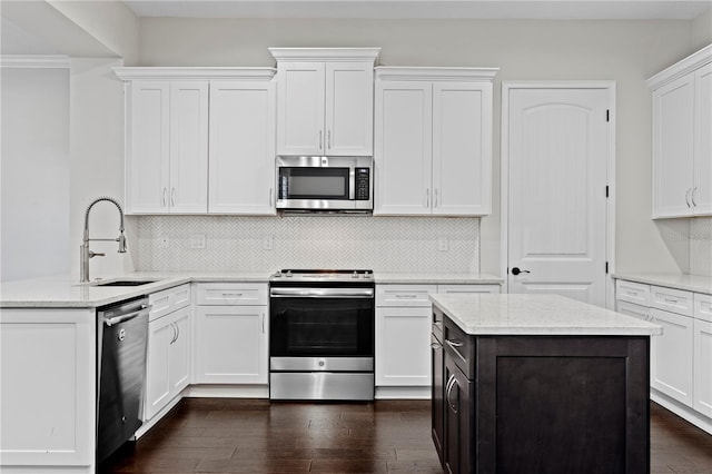 4606 W Fig St Unit 4, Tampa, FL 33609 - kitchen with stainless steel appliances, a sink, white cabinetry, dark wood-style flooring, and backsplash