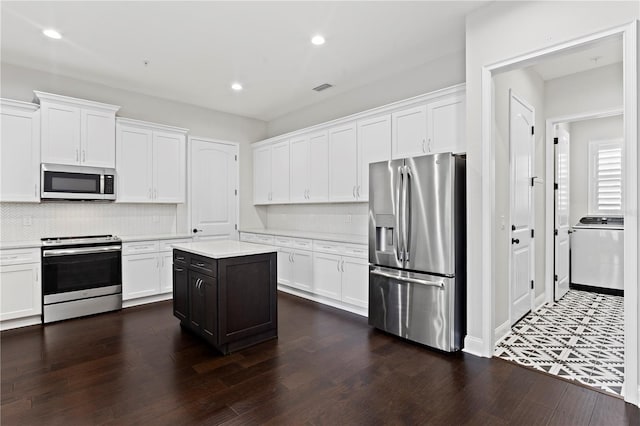 4606 W Fig St Unit 4, Tampa, FL 33609 - kitchen with appliances with stainless steel finishes, washer / clothes dryer, light countertops, white cabinets, and recessed lighting