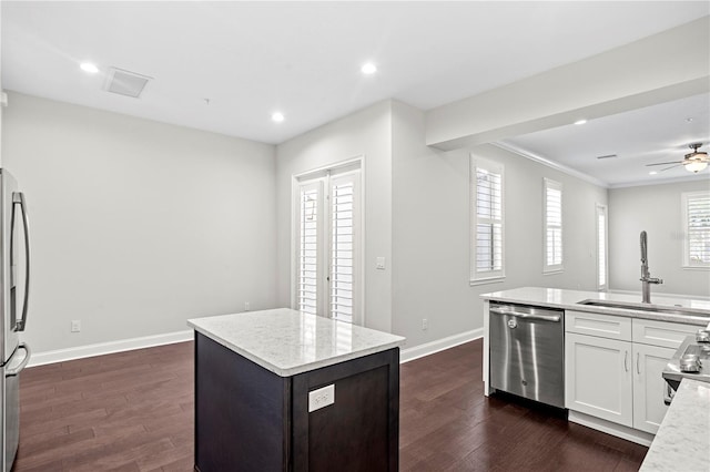 4606 W Fig St Unit 4, Tampa, FL 33609 - kitchen with stainless steel appliances, a sink, a kitchen island, dark wood-style floors, and crown molding