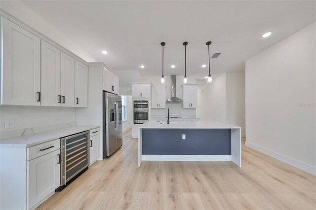 kitchen with beverage cooler, white cabinetry, hanging light fixtures, light hardwood / wood-style flooring, and stainless steel appliances