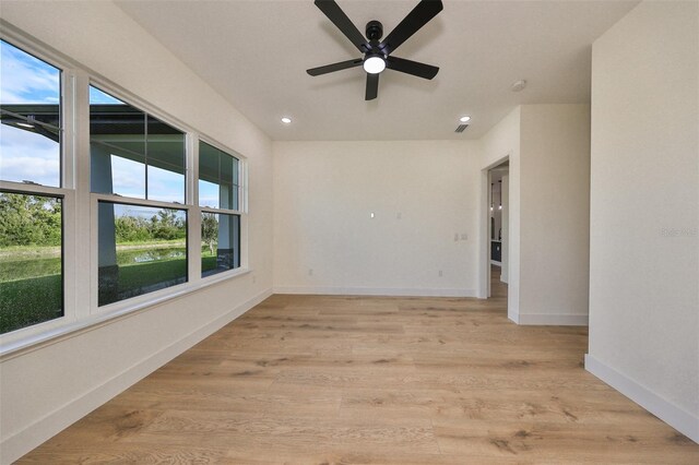 spare room with light hardwood / wood-style floors, ceiling fan, and a healthy amount of sunlight