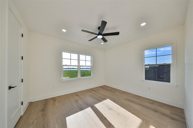 unfurnished room with light hardwood / wood-style floors, ceiling fan, and plenty of natural light