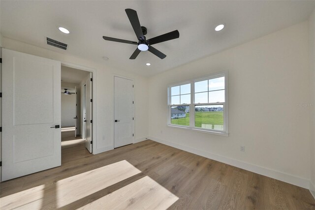 unfurnished bedroom with ceiling fan and wood-type flooring