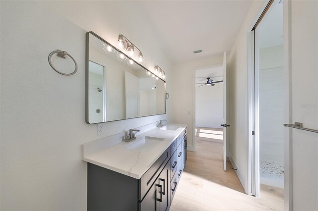 bathroom with ceiling fan, walk in shower, hardwood / wood-style flooring, and vanity