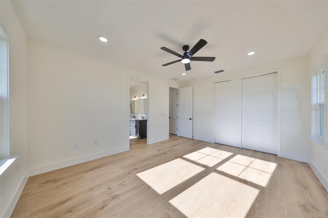 unfurnished bedroom with light hardwood / wood-style floors, ceiling fan, ensuite bathroom, and a closet