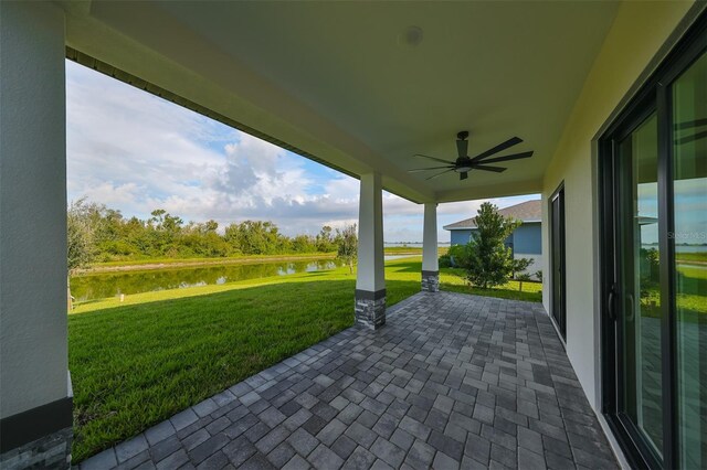 view of patio with a water view and ceiling fan