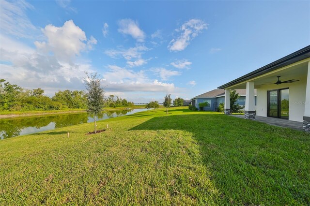 view of yard featuring a patio, a water view, and ceiling fan