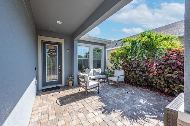 doorway to property with an outdoor living space and a patio