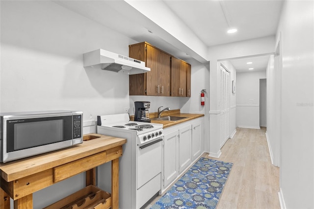 kitchen with white cabinetry, sink, white gas stove, exhaust hood, and light wood-type flooring