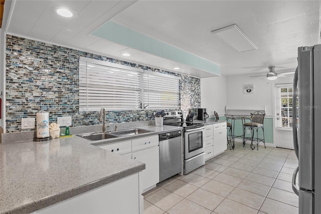 kitchen featuring sink, ceiling fan, tasteful backsplash, white cabinetry, and stainless steel appliances