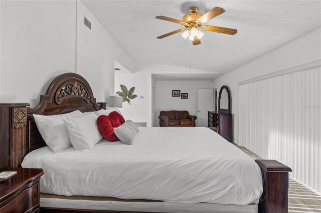 bedroom featuring lofted ceiling, ceiling fan, and a textured ceiling