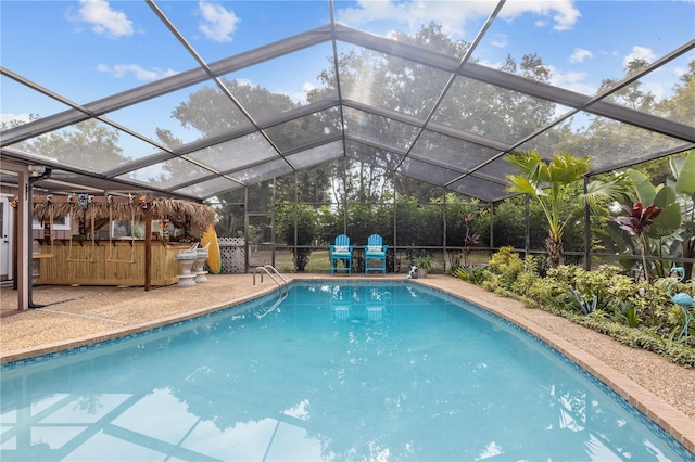 view of swimming pool featuring glass enclosure