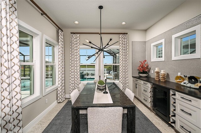 kitchen with decorative light fixtures, an inviting chandelier, tile flooring, white cabinetry, and a center island