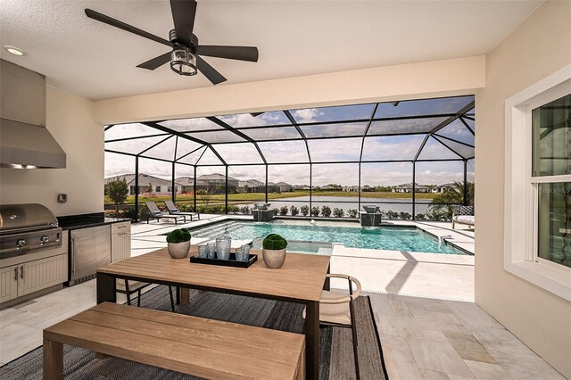 view of swimming pool with ceiling fan, pool water feature, a patio, area for grilling, and glass enclosure