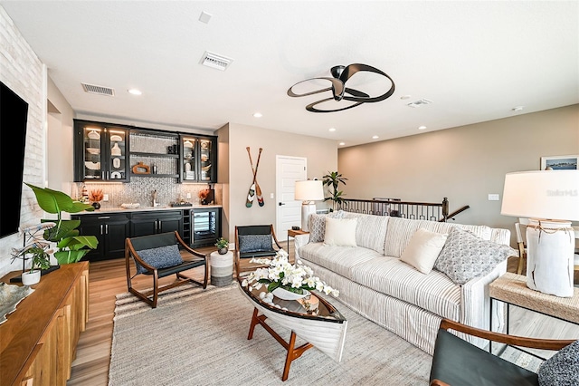 living room featuring wine cooler and light hardwood / wood-style floors