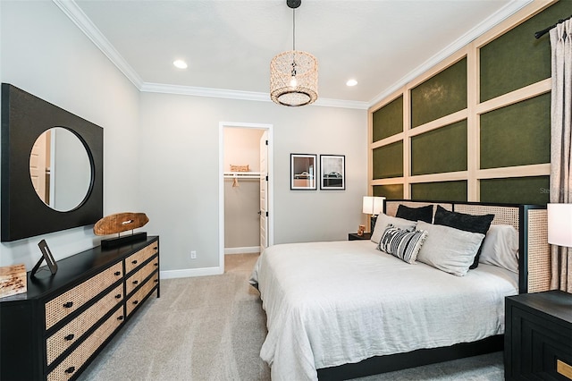 carpeted bedroom with a closet, crown molding, and a walk in closet