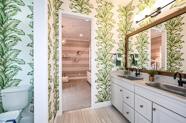 bathroom featuring crown molding, dual vanity, and toilet