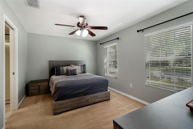 carpeted bedroom featuring ceiling fan and multiple windows