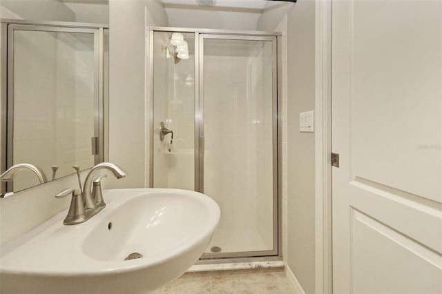 bathroom featuring tile patterned flooring, a shower with door, and sink