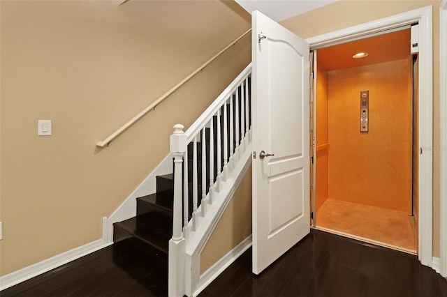 stairs with hardwood / wood-style floors and elevator