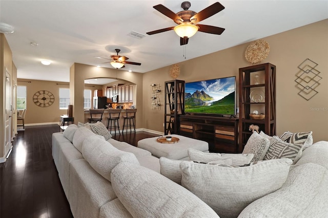 living room with ceiling fan and dark hardwood / wood-style flooring