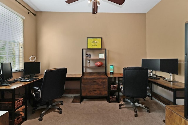 carpeted home office featuring ceiling fan