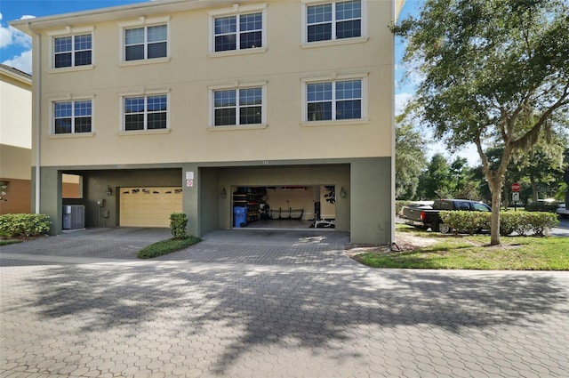 view of front of property with central AC unit and a garage