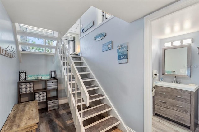 staircase featuring hardwood / wood-style flooring and sink