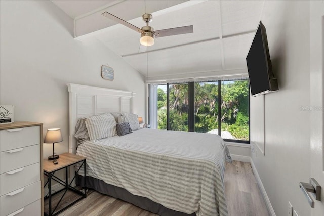 bedroom featuring ceiling fan, light hardwood / wood-style flooring, and vaulted ceiling with beams