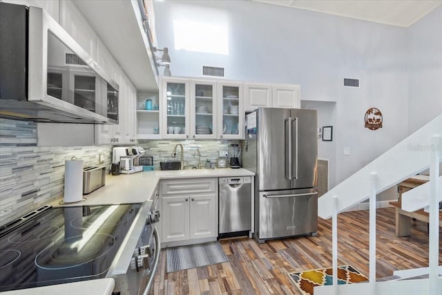 kitchen featuring sink, white cabinets, decorative backsplash, and appliances with stainless steel finishes