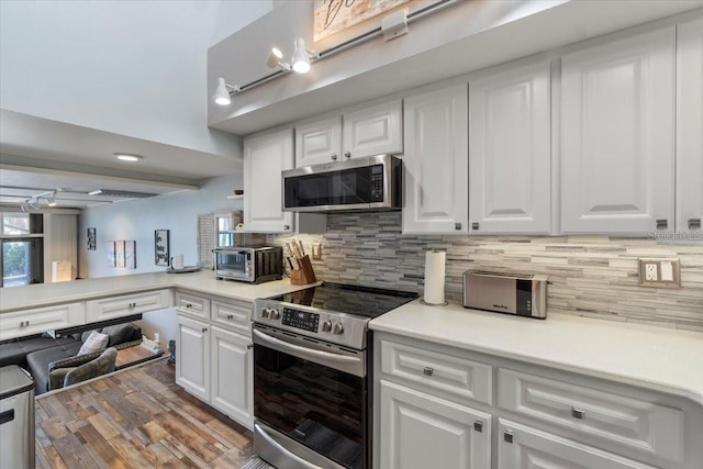 kitchen with stainless steel appliances, backsplash, and white cabinetry