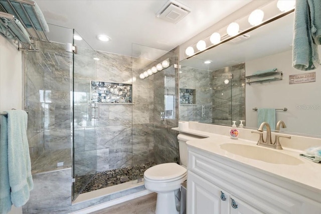 bathroom with walk in shower, hardwood / wood-style flooring, vanity, and toilet