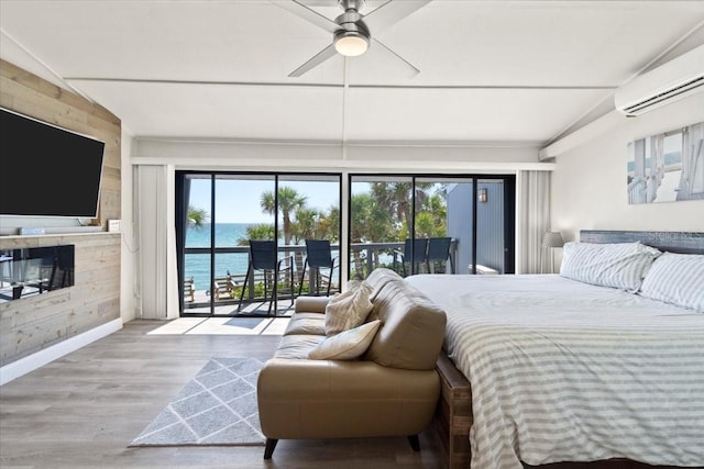 bedroom with access to exterior, ceiling fan, vaulted ceiling, and a water view