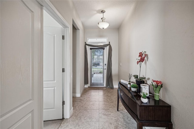 tiled entryway featuring a textured ceiling