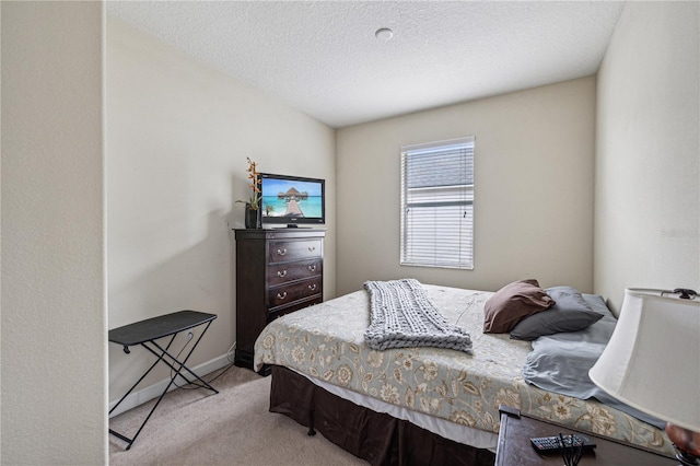 bedroom featuring a textured ceiling and light colored carpet