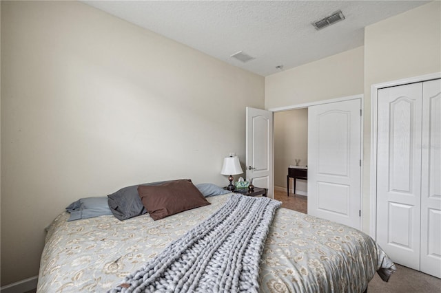 bedroom with a closet, a textured ceiling, and carpet floors