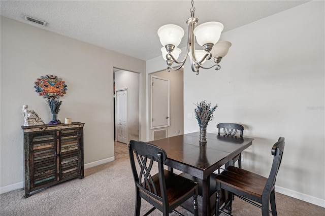 carpeted dining room with an inviting chandelier and a textured ceiling