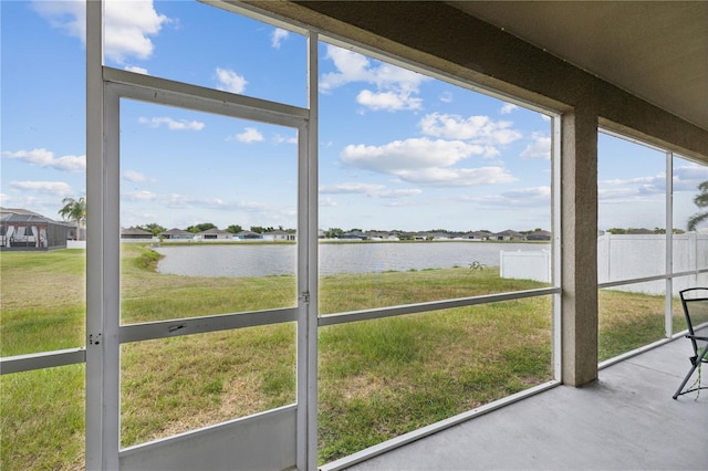 unfurnished sunroom featuring a water view