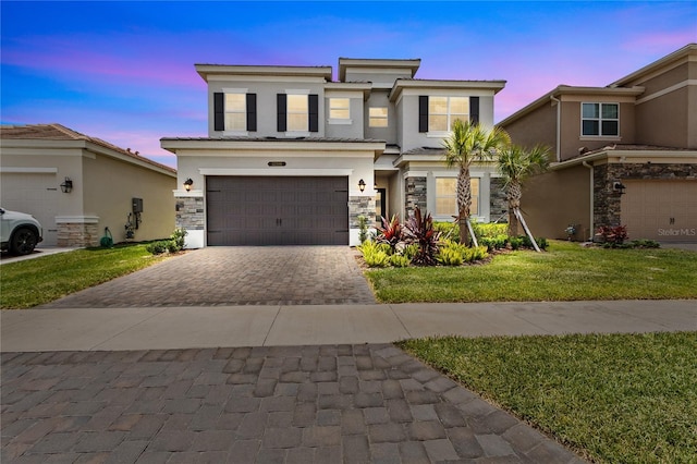 view of front of house featuring a garage and a yard