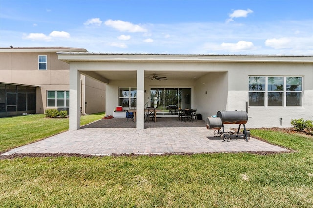 back of house featuring a lawn, ceiling fan, and a patio