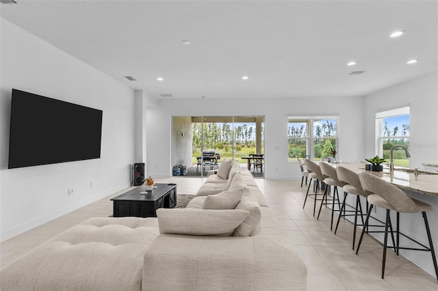 living room featuring sink and light tile patterned floors