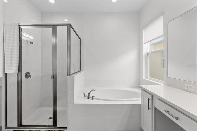 bathroom featuring plus walk in shower, vanity, and a wealth of natural light