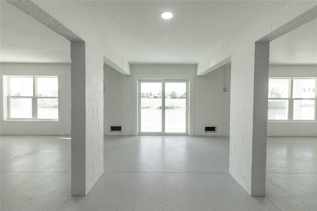 3431 Sheephead Dr, Hernando Beach, FL 34607 - unfurnished room with speckle patterned floor and plenty of natural light