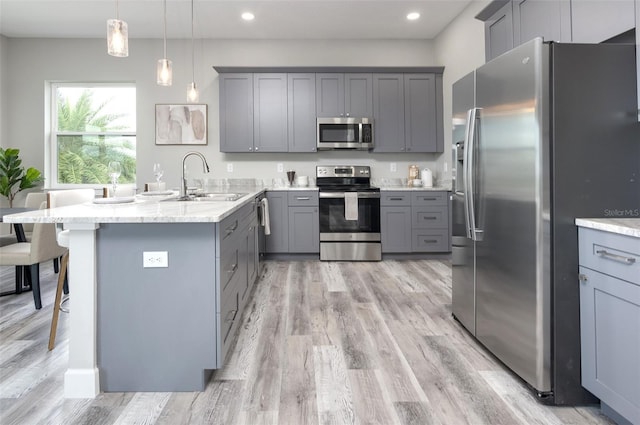 3431 Sheephead Dr, Hernando Beach, FL 34607 - kitchen featuring appliances with stainless steel finishes, gray cabinetry, a peninsula, light wood finished floors, and recessed lighting