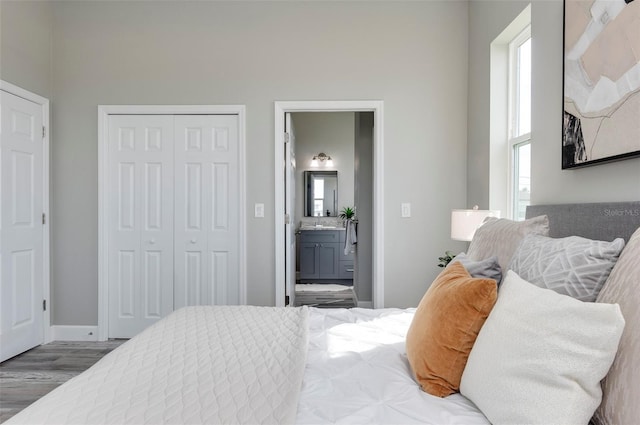 3431 Sheephead Dr, Hernando Beach, FL 34607 - bedroom featuring wood finished floors, a closet, connected bathroom, and baseboards