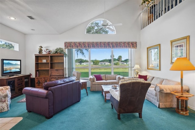 living room featuring a towering ceiling, carpet floors, and ceiling fan