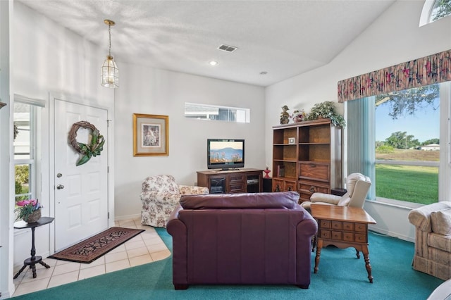 living room featuring a textured ceiling, vaulted ceiling, tile patterned floors, and a healthy amount of sunlight