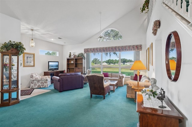 carpeted living room with high vaulted ceiling and ceiling fan