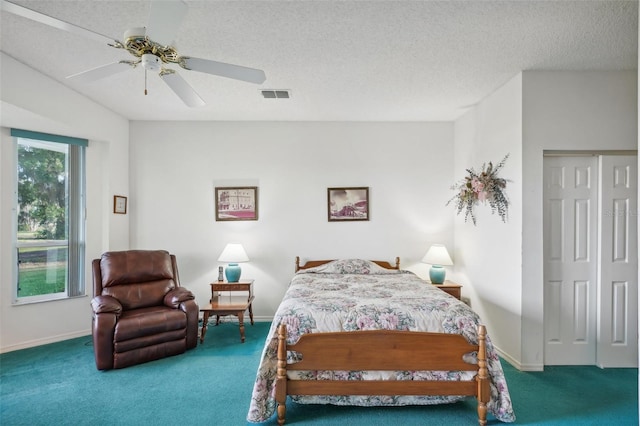 carpeted bedroom with ceiling fan and a textured ceiling