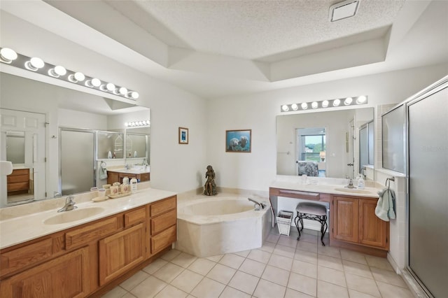 bathroom featuring tile patterned flooring, shower with separate bathtub, a textured ceiling, and a tray ceiling